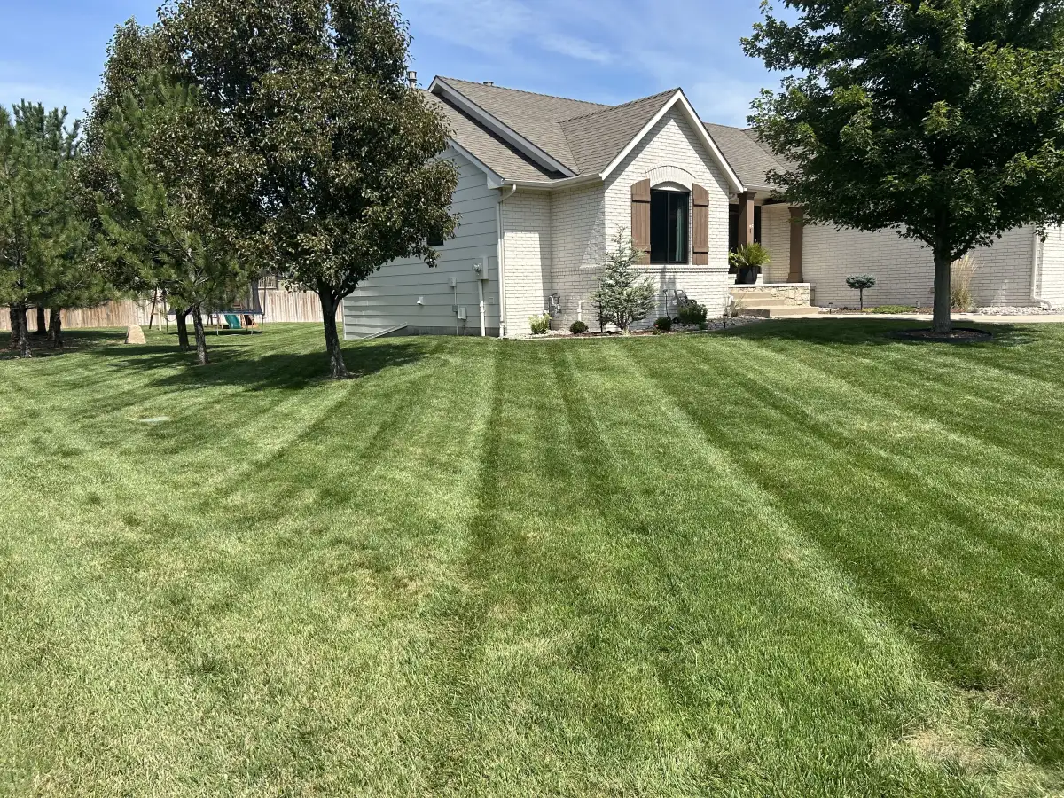 Professional lawn service team maintaining a residential property in Wichita Kansas