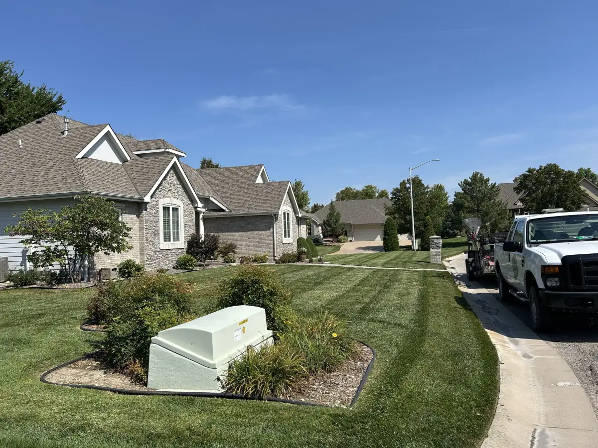 Neighborhood lawn maintained with regular mowing and trimming service